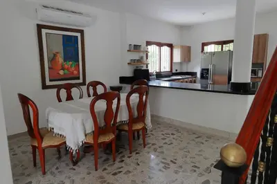 a dining room with a table and chairs and a kitchen at Acogedora Casa-Finca en Sopetran, Antioquia in Corral Falso