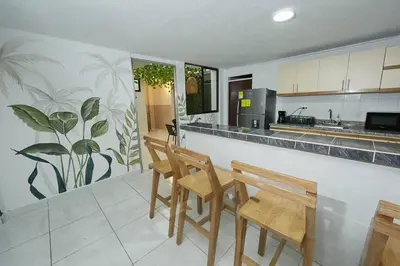 a kitchen with wooden chairs and a counter top at Acogedora casa cerca al estadio in Robledo