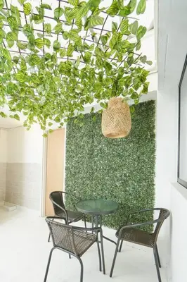 a table and chairs in front of a green wall at Acogedora casa cerca al estadio in Robledo