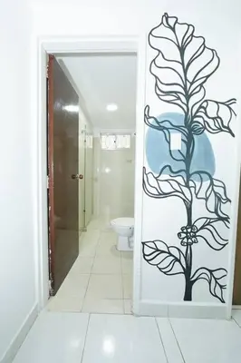 a bathroom with a door with a plant painted on it at Acogedora casa cerca al estadio in Robledo