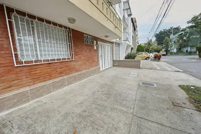 a brick building with a white door on a street at Acogedora casa cerca al estadio in Robledo