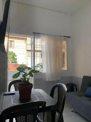 a living room with a table with a plant on it at Hostal CasaBlanca, Laureles Estadio in Medellín