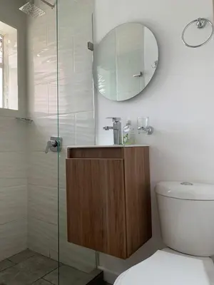 a bathroom with a shower and a toilet and a mirror at Hostal CasaBlanca, Laureles Estadio in Medellín