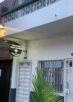 a sign that is on the side of a building at Hostal CasaBlanca, Laureles Estadio in Medellín