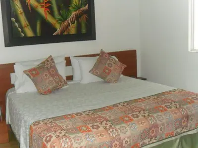 a bedroom with a bed with pillows on it at Hotel Bella Montaña in Manizales