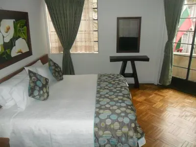 a bedroom with a bed and a desk in a room at Hotel Bella Montaña in Manizales