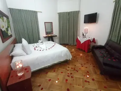 a bedroom with a bed and a couch and a television at Hotel Bella Montaña in Manizales