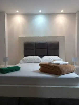 a bedroom with a large white bed with a headboard at Vista de lujo en Guatapé in Guatapé