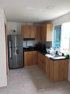 a kitchen with wooden cabinets and a stainless steel refrigerator at Vista de lujo en Guatapé in Guatapé