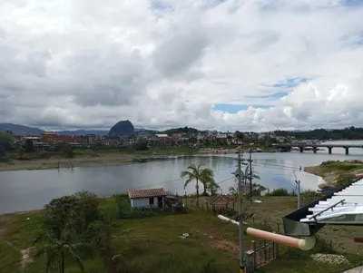 a view of a river with a town and a bridge at Vista de lujo en Guatapé in Guatapé
