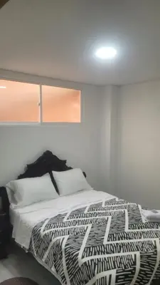a bedroom with a bed with a black and white comforter at Vista de lujo en Guatapé in Guatapé