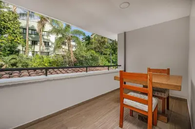 a wooden table and a chair in a room with a window at white house poblado in El Poblado