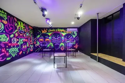 a room with chairs and a wall covered in graffiti at white house poblado in El Poblado
