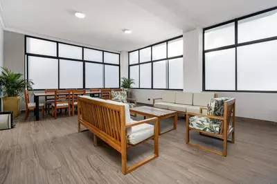 a waiting room with tables and chairs and windows at white house poblado in El Poblado
