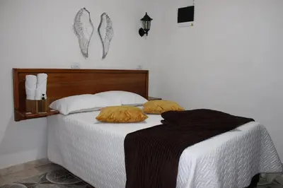 a bed with two pillows on it in a bedroom at Donde María Yarce Casa Turística in Jardin