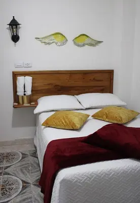 a bedroom with a large bed with two pillows at Donde María Yarce Casa Turística in Jardin