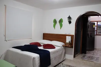 a bedroom with two beds with white sheets and red pillows at Donde María Yarce Casa Turística in Jardin