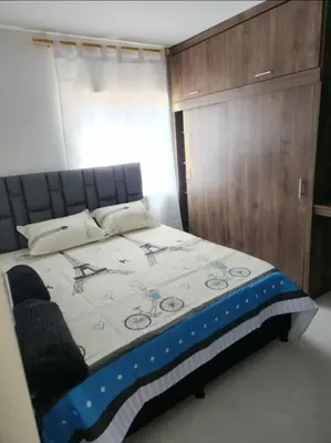 a bedroom with a bed and a wooden cabinet at GIGANTE y ELEGANTE APARTAMENTO UNIFAMILIAR in Belén