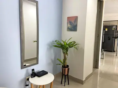 a hallway with a table and a potted plant at Central Family Home with Air Conditioning in Sabaneta