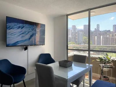 a living room with a table and chairs and a tv at Central Family Home with Air Conditioning in Sabaneta