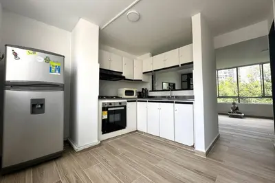 a kitchen with white cabinets and a refrigerator at Charm of Las Palmas in El Salvador