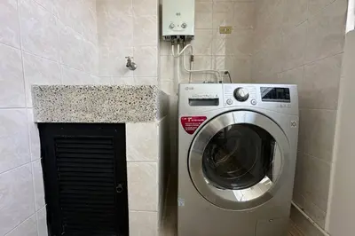 a washing machine in a bathroom next to a counter at Charm of Las Palmas in El Salvador
