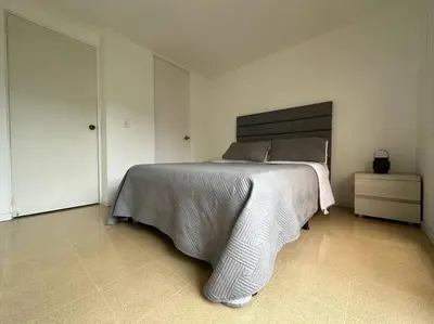 a bedroom with a large bed in a white room at Cozy Studio Apartment in Poblado with Jacuzzi in Medellín