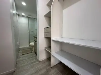 a white bathroom with a toilet and a walk in closet at Cozy Studio Apartment in Poblado with Jacuzzi in Medellín