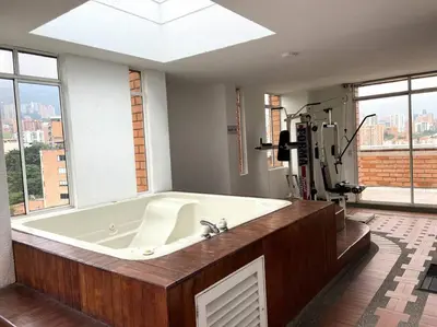 a large bath tub in a bathroom with a large window at Cozy Studio Apartment in Poblado with Jacuzzi in Medellín