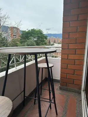 a table and two stools sitting on a balcony at Cozy Studio Apartment in Poblado with Jacuzzi in Medellín