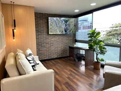 a living room with a white couch and a desk at Elegance in Provenza in El Poblado