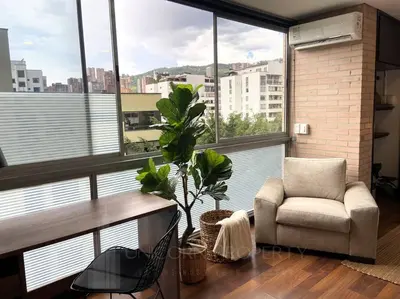 a living room with a chair and a large window at Elegance in Provenza in El Poblado