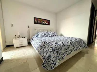 a bedroom with a bed and a dresser in it at Magical Laureles in Medellín