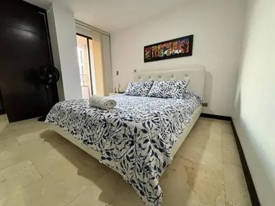 a bedroom with a bed with a black and white comforter at Magical Laureles in Medellín
