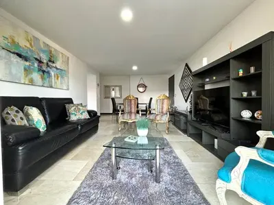 a living room with a black couch and a table at Magical Laureles in Medellín