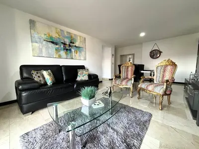 a living room with a black leather couch and chairs at Magical Laureles in Medellín