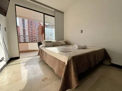 a bedroom with a large bed with a large window at Magical Laureles in Medellín