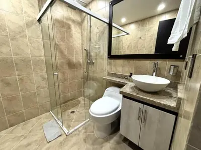a bathroom with a toilet and a sink and a shower at Magical Laureles in Medellín