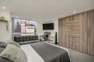 a bedroom with a large bed and a large window at Aparta Estudio en Edificio La Frontera in Medellín