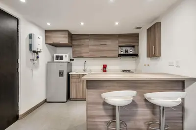 a kitchen with a counter and two stools at Aparta Estudio en Edificio La Frontera in Medellín