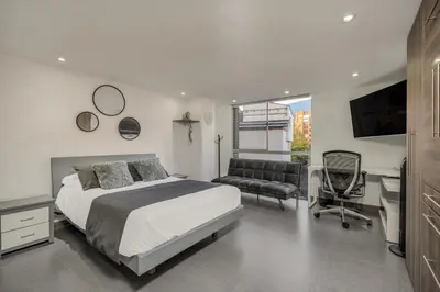 a bedroom with a bed and a desk and a chair at Aparta Estudio en Edificio La Frontera in Medellín