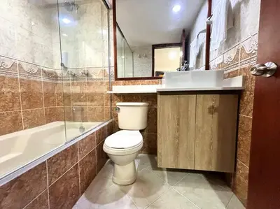 a bathroom with a toilet and a tub and a sink at Serene Laureles in América