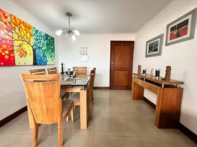 a dining room with a table and a painting on the wall at Serene Laureles in América