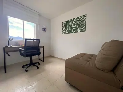 a living room with a couch and a desk and a chair at Serenity in Poblado in El Poblado