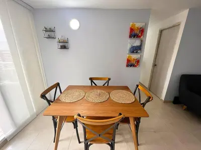 a wooden table and chairs in a living room at Serenity in Poblado in El Poblado