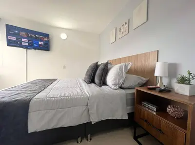 a bedroom with a large bed and a wooden dresser at Serenity in Poblado in El Poblado