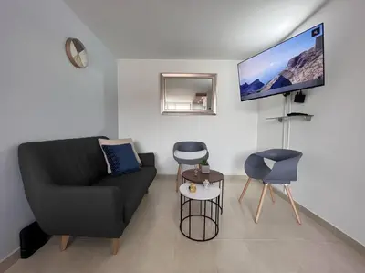 a living room with a black couch and a flat screen tv at Serenity in Poblado in El Poblado