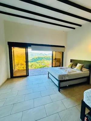 a bedroom with a bed and a large window at Cabaña Cedro Amarillo - Jacuzzi Grande Con Calefacción - Cerca a Medellín in Sopetran