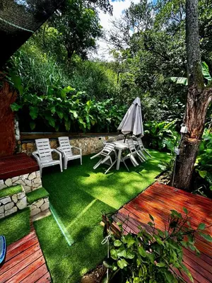 a backyard with chairs and an umbrella and grass at Cabaña Cedro Amarillo - Jacuzzi Grande Con Calefacción - Cerca a Medellín in Sopetran