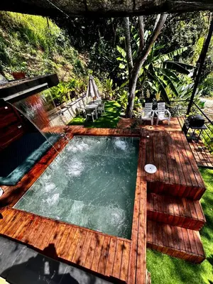 a swimming pool on a wooden deck with some chairs at Cabaña Cedro Amarillo - Jacuzzi Grande Con Calefacción - Cerca a Medellín in Sopetran